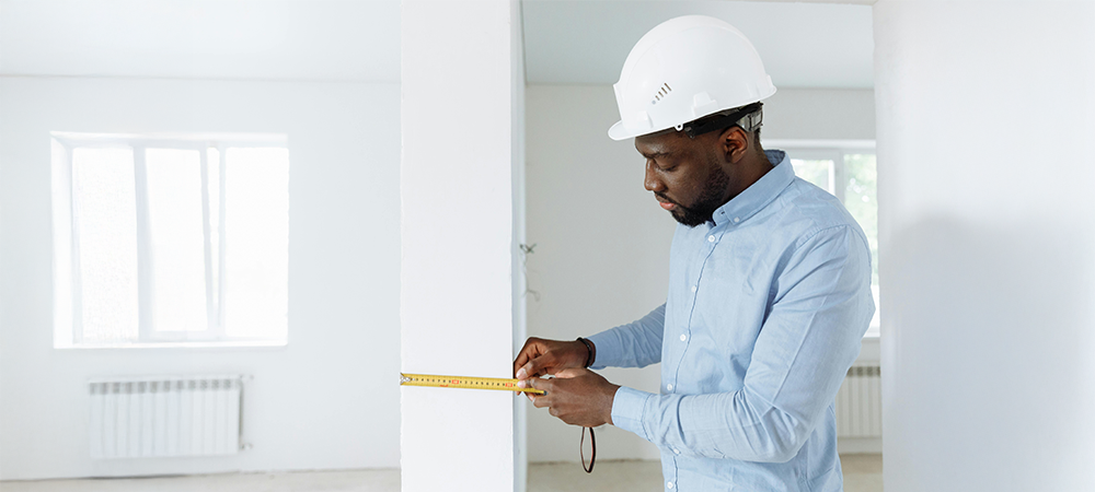 Contractor measuring kitchen space for cabinet installation Contractor measuring kitchen space for cabinet installation
