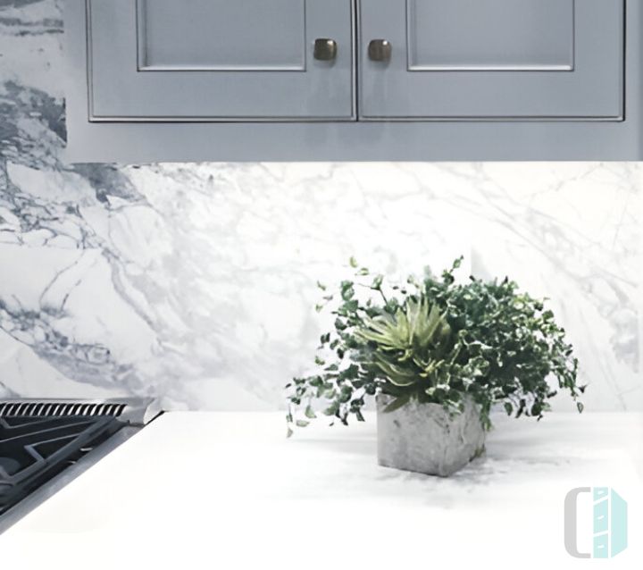 A modern kitchen with gray cabinets and a single slab marble backsplash A modern kitchen with gray cabinets and a single slab marble backsplash